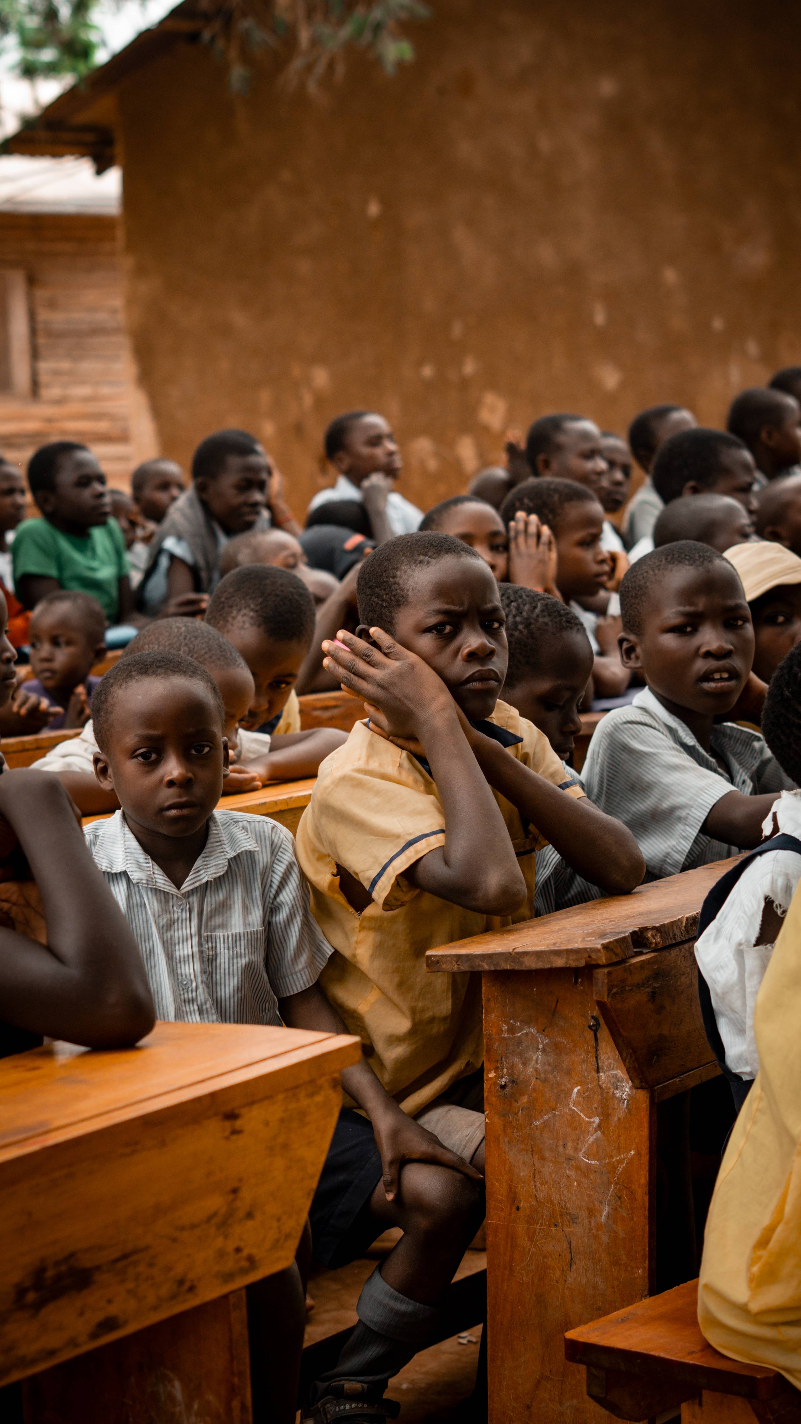 Students seated at desks in outdoor classroom